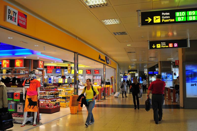 Reisende im Flughafenterminal mit Wegweisern