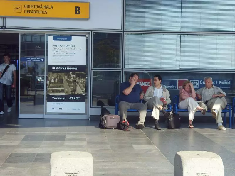Reisende mit Gepäck vor der Abflughalle am Flughafen Prag