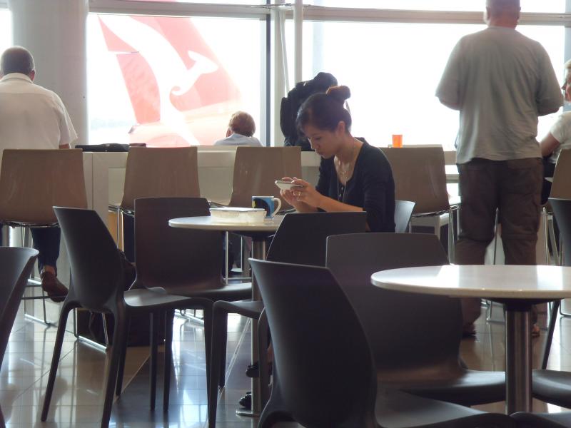 Reisende mit Smartphone in einer Flughafenlounge