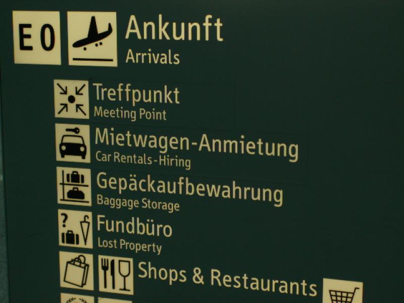 Flughafenschild mit Ankunft und Treffpunkt