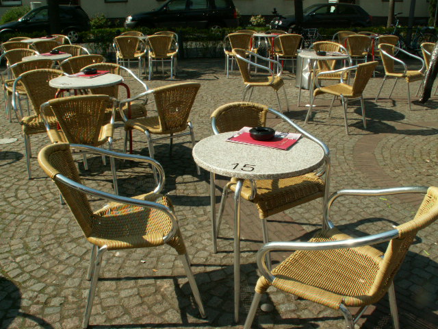 Sitzplätze eines Straßencafés auf einem Stadtplatz