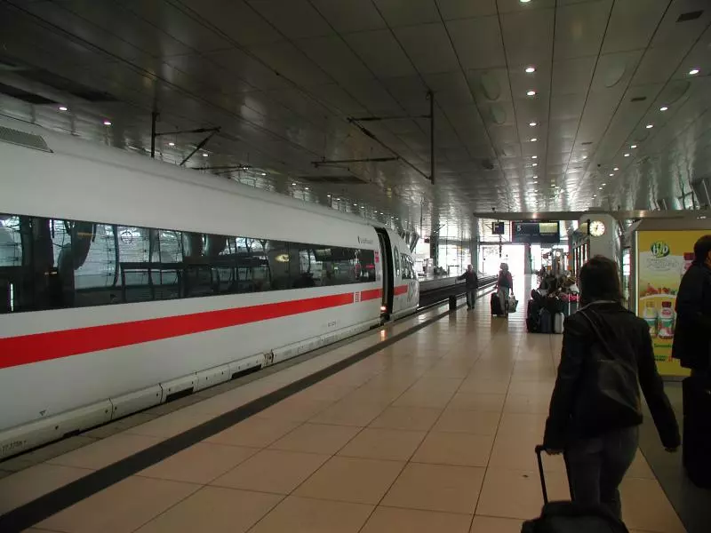 Schnellzug und Reisende am Bahnsteig